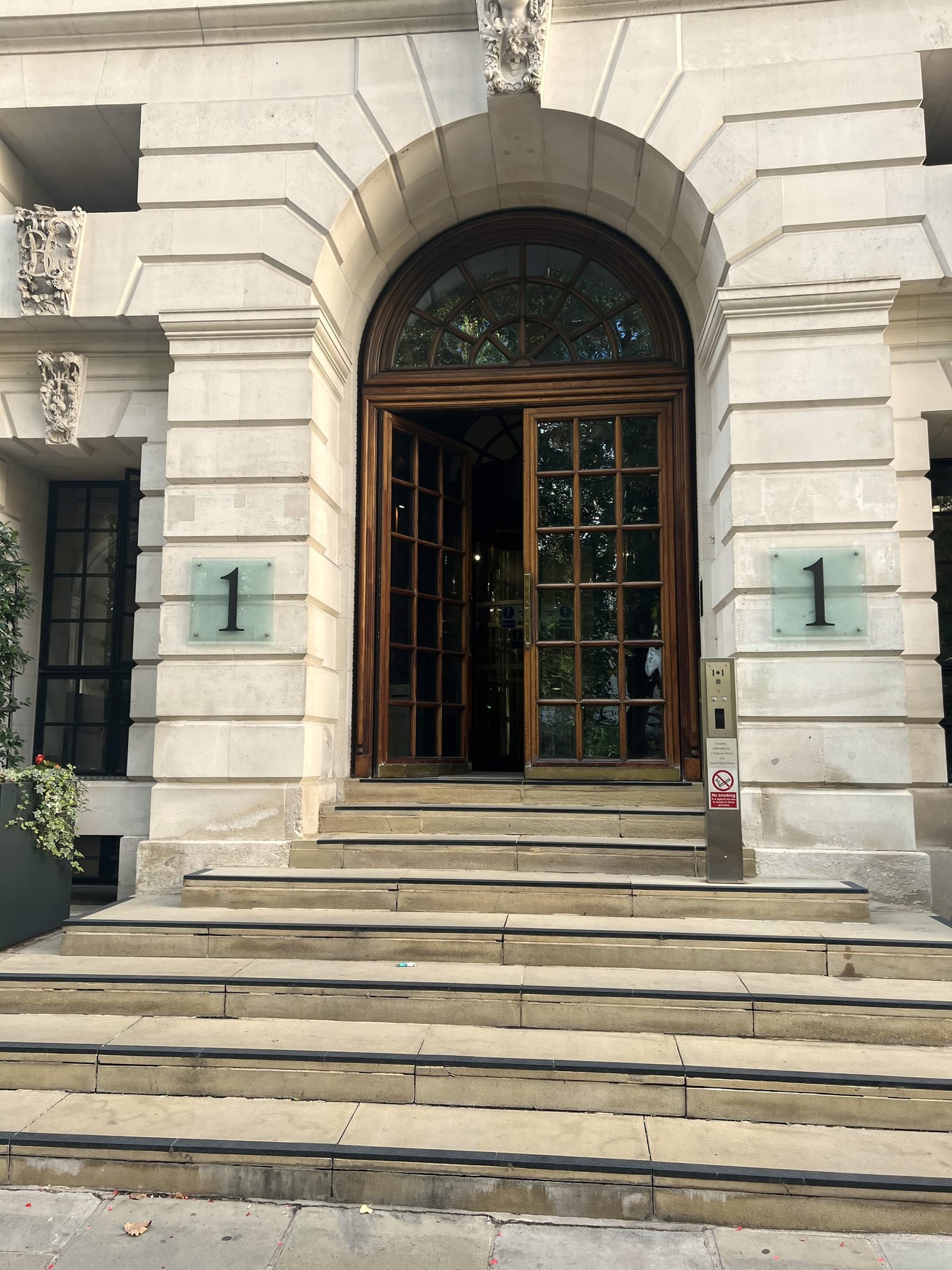 Open timber doors beneath a stone arch at the top of wide steps